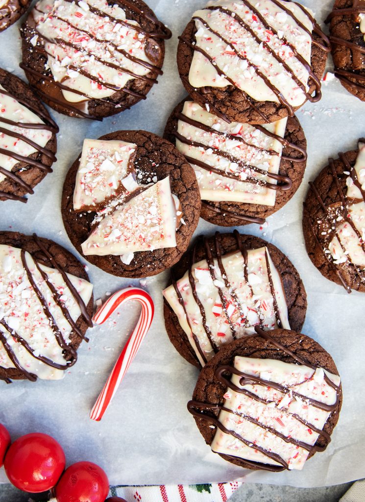 An overhead photo of brownie cookies topped with Peppermint bark squares and a drizzle of chocolate.