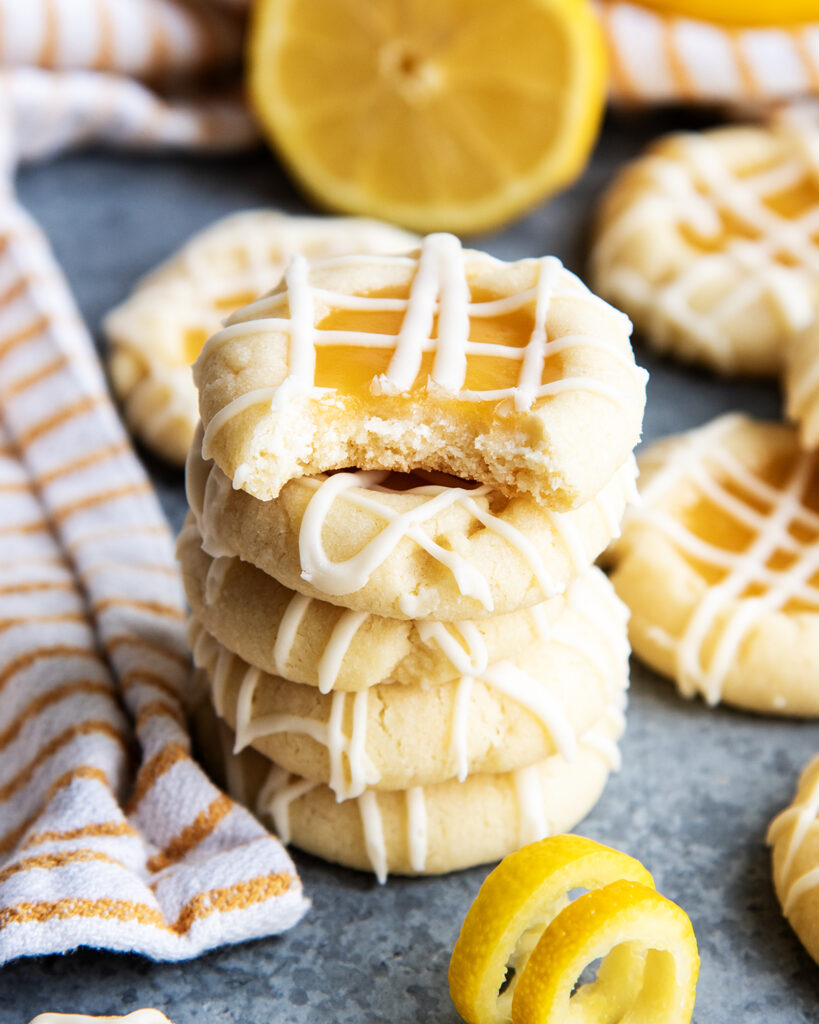 A stack of lemon curd cookies. The top cookie has a bite out of it.
