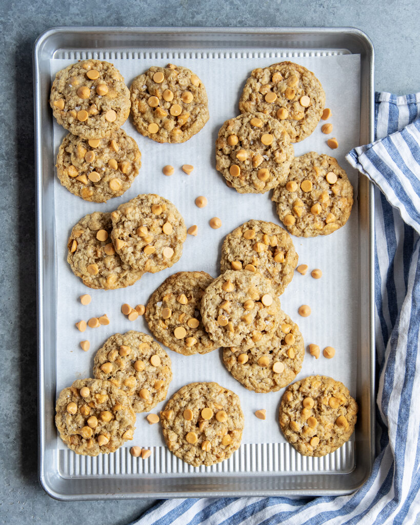 A cookie sheet topped with piles of oatmeal butterscotch cookies.