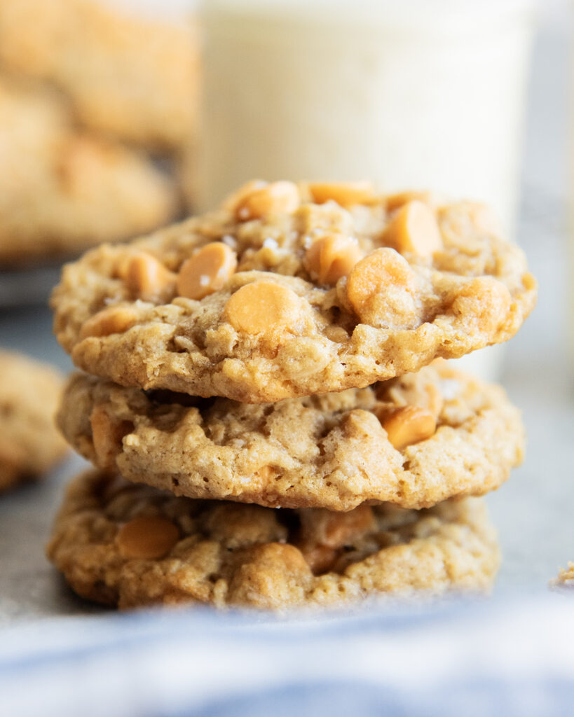 A stack of 3 oatmeal butterscotch cookies full of butterscotch chips.