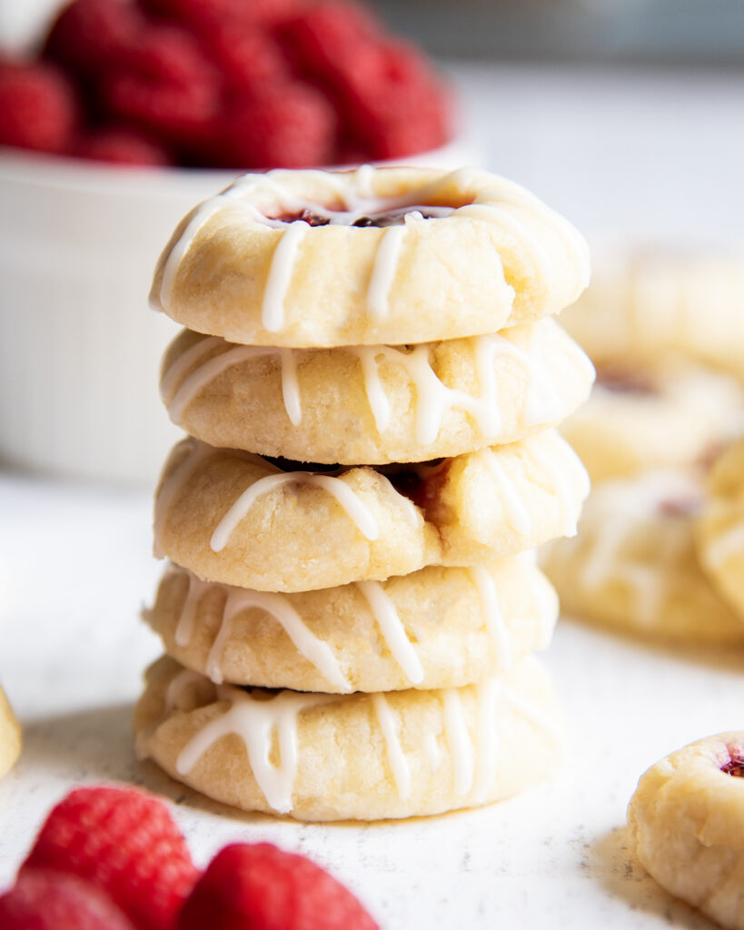 A stack of 5 thumbprint cookies, drizzled with icing.