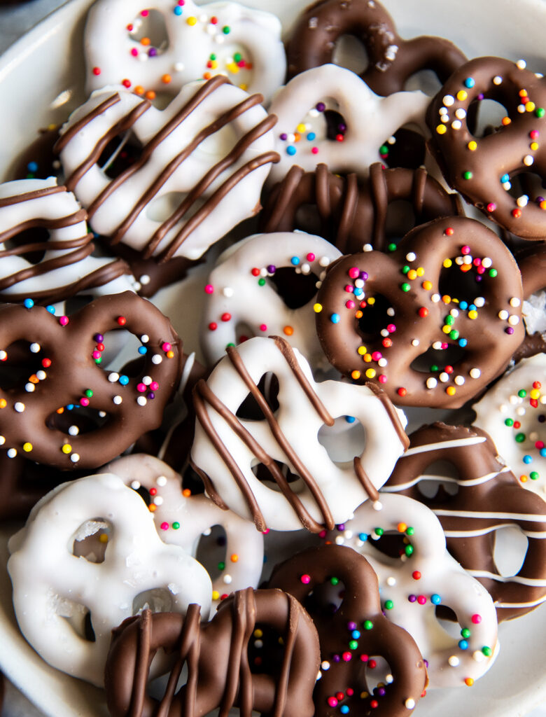 A close up of a pile of chocolate covered pretzels on a plate.