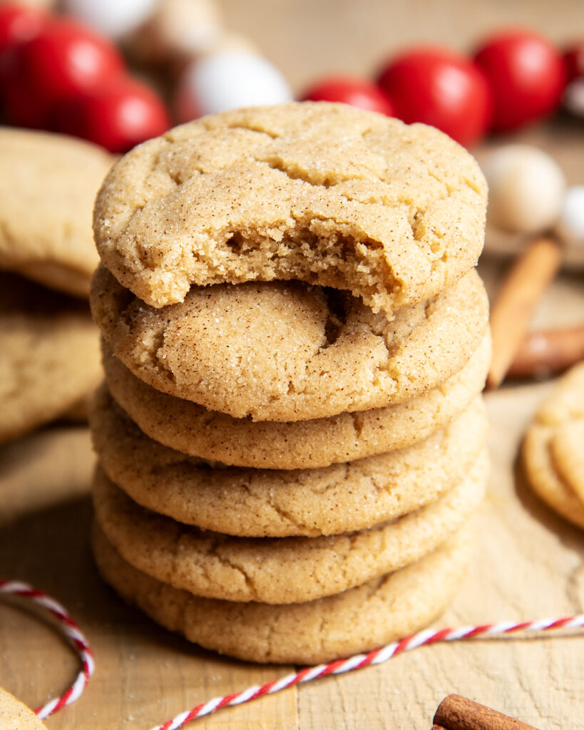 A stack of cinnamon sugar coated cookies, and the top cookie has a bite out of it.