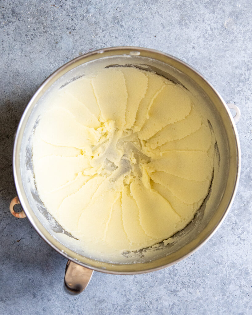 A mixing bowl of creamed butter and sugar. 