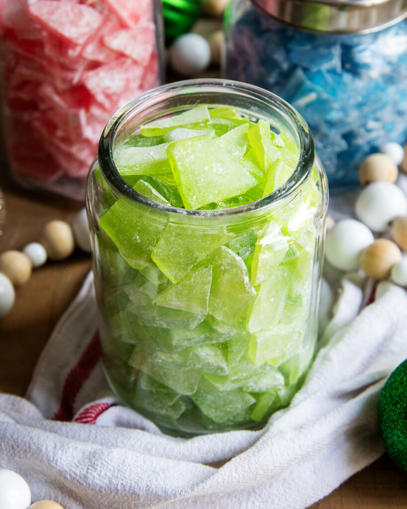 A glass jar of green rock candy pieces.