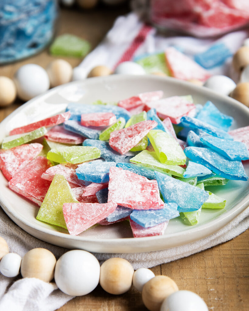 A plate of different shaped hard candy pieces in the colors red, green, and blue.