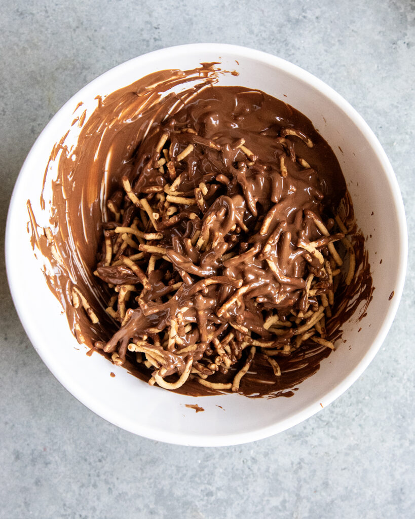 A bowl of melted chocolate and chow mein noodles.