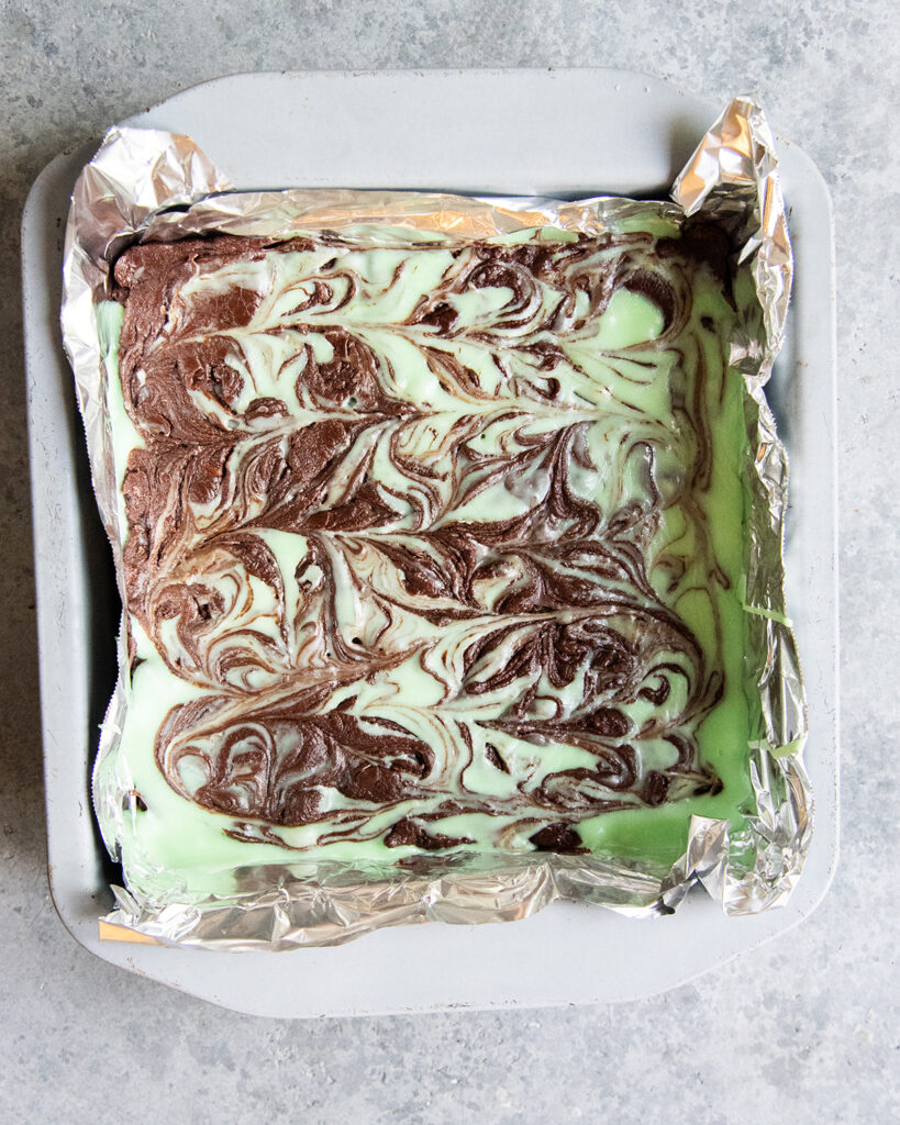 Mint Chocolate Fudge swirled in a parchment paper lined baking pan.