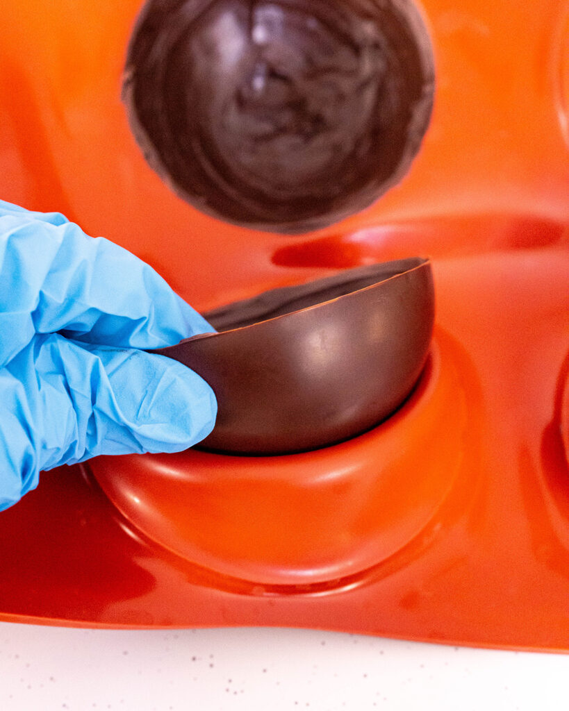Half a chocolate sphere in a silicone mold.