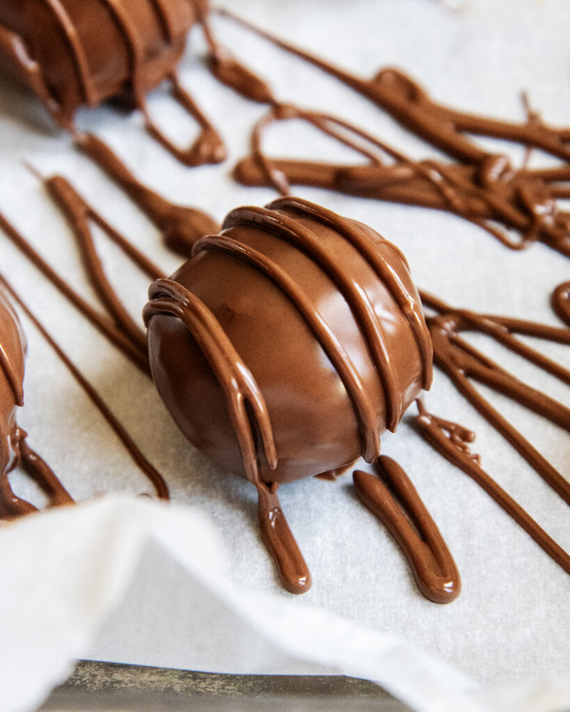 A chocolate truffle drizzled with melted chocolate over the top.