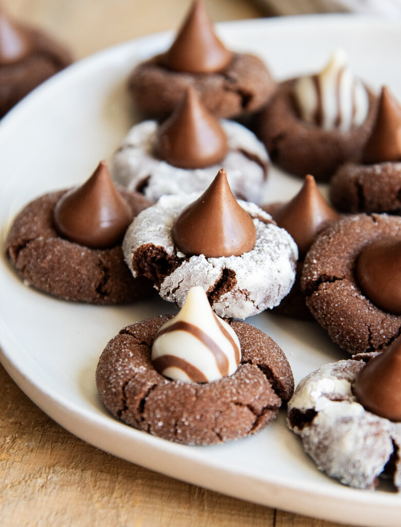 A plate of Chocolate blossom cookies, some are coated in powdered sugar and some in granulated sugar.