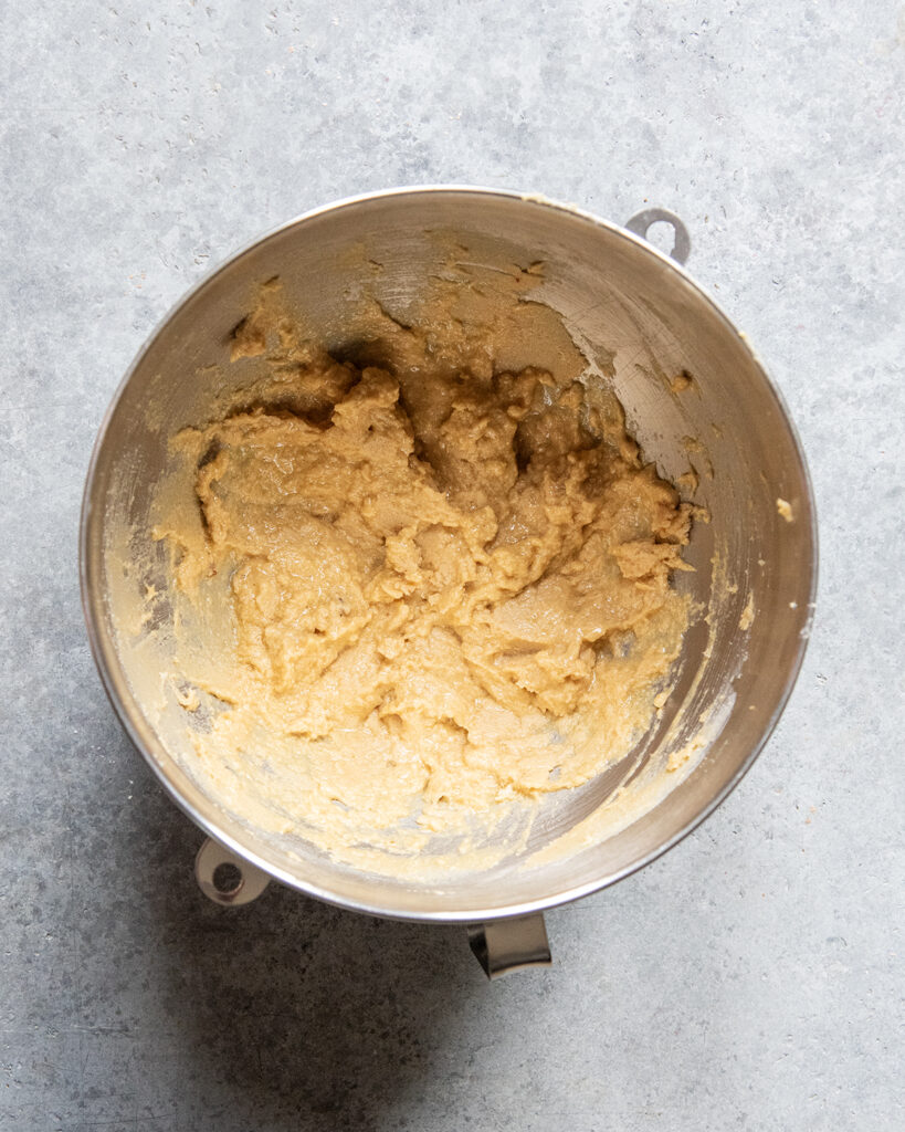 A bowl of wet ingredients for cookies, eggs, sugar, and butter.