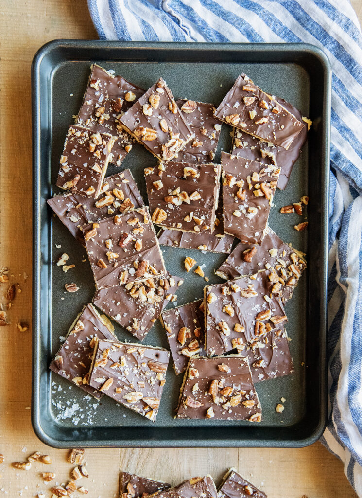 An above view of a tray of Cracker toffee topped with pecans.