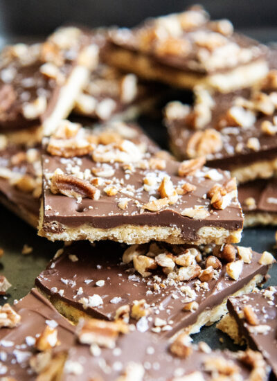 Pieces of cracker toffee topped with chocolate on a metal tray.
