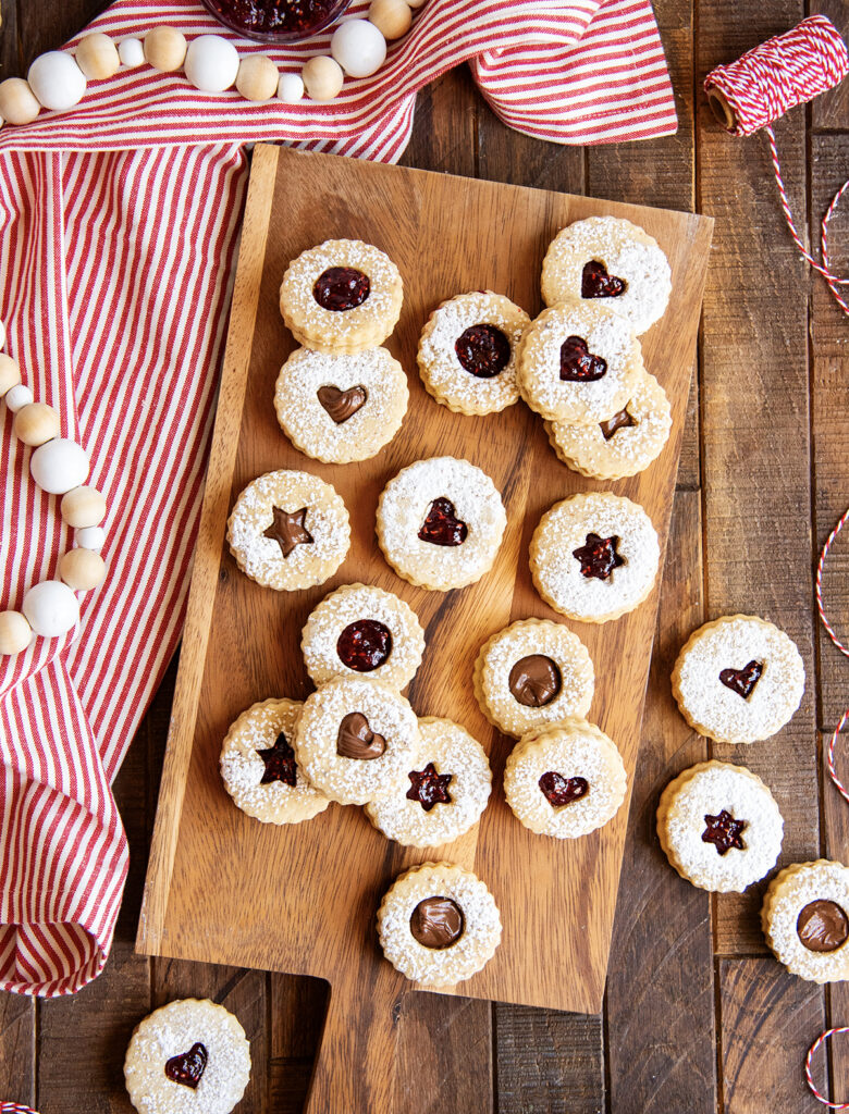 A wooden cutting board topped with sandwich cookies.