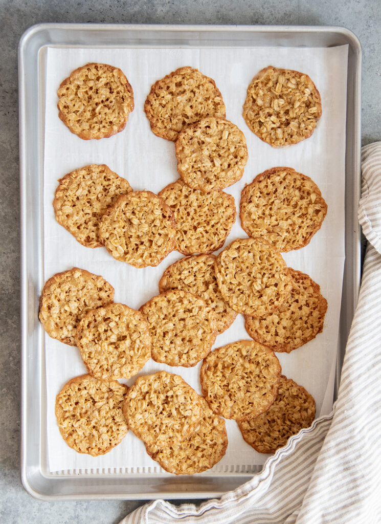 A cookie sheet of oatmeal lace cookies assorted randomly.