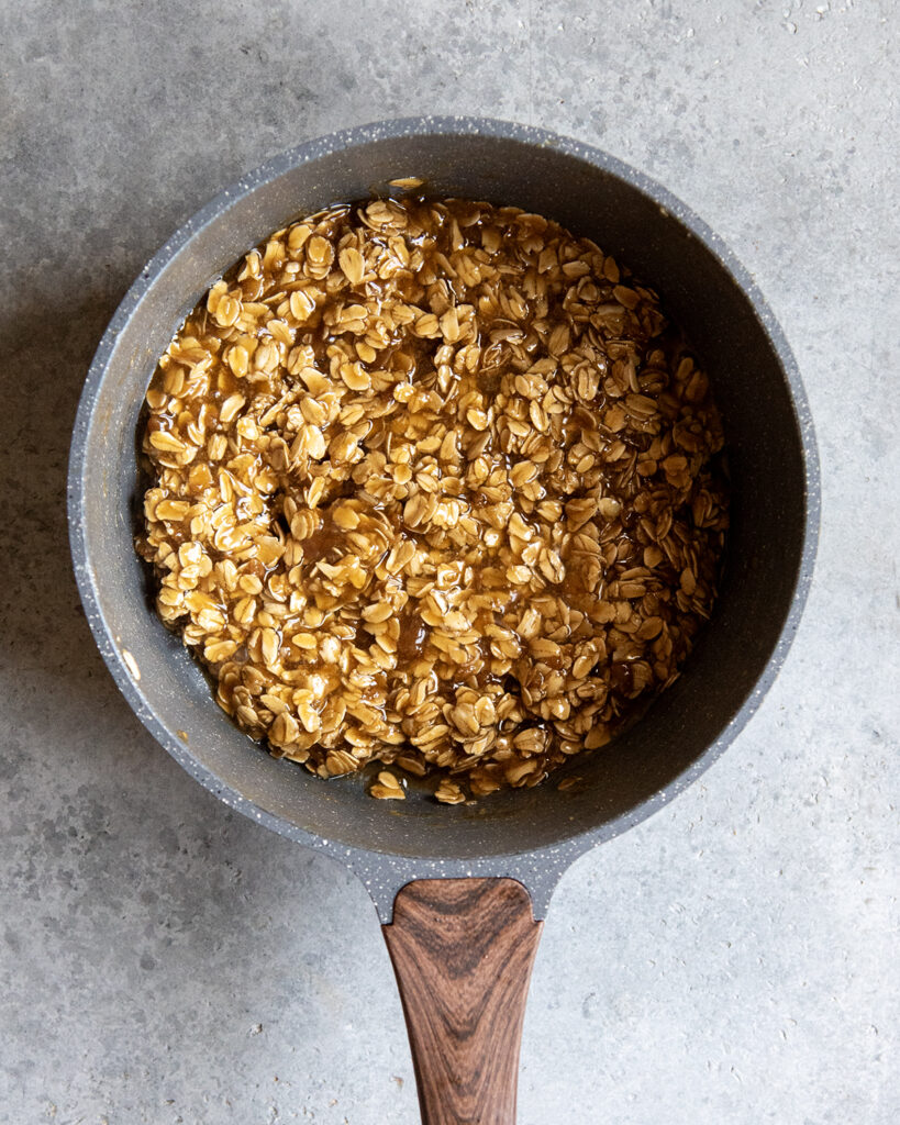 A sauce pan full of a brown caramel and oat mixture.