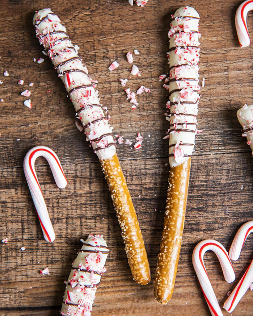 Peppermint bark covered pretzels on a wooden board.