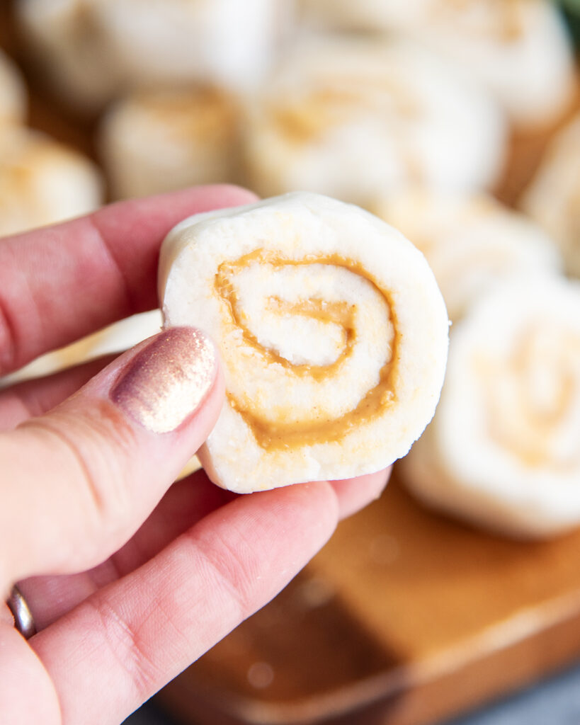 A hand holding a peanut butter and potato candy pinwheel.