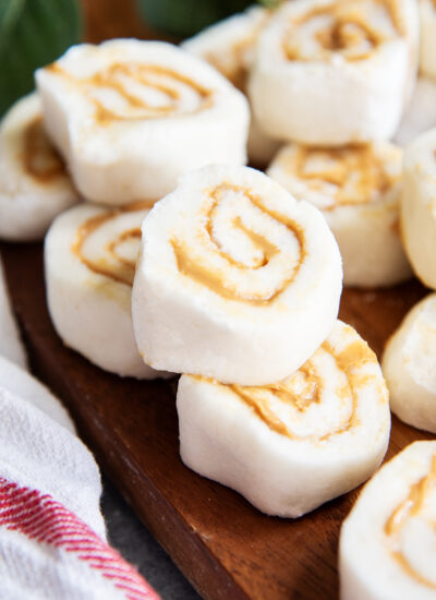 A stack of peanut butter pinwheel candies on a wooden board.