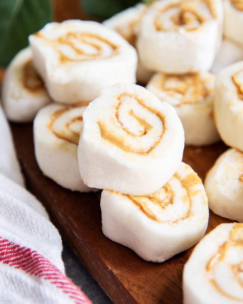 A stack of peanut butter pinwheel candies on a wooden board.