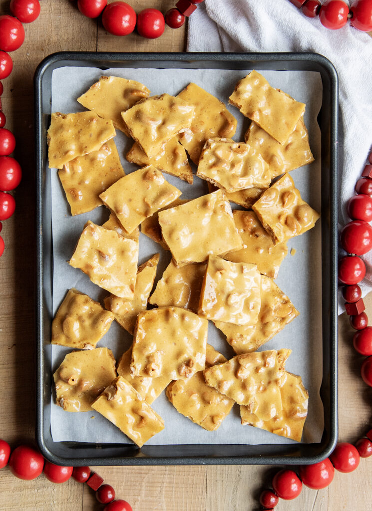 An above view of cashew brittle pieces on a cookie sheet.