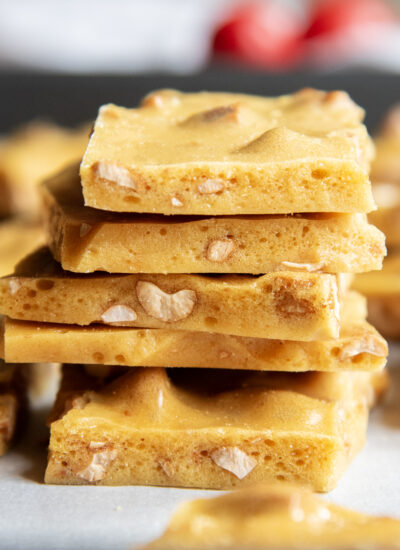 A stack of cashew brittle pieces on a cookie tray.