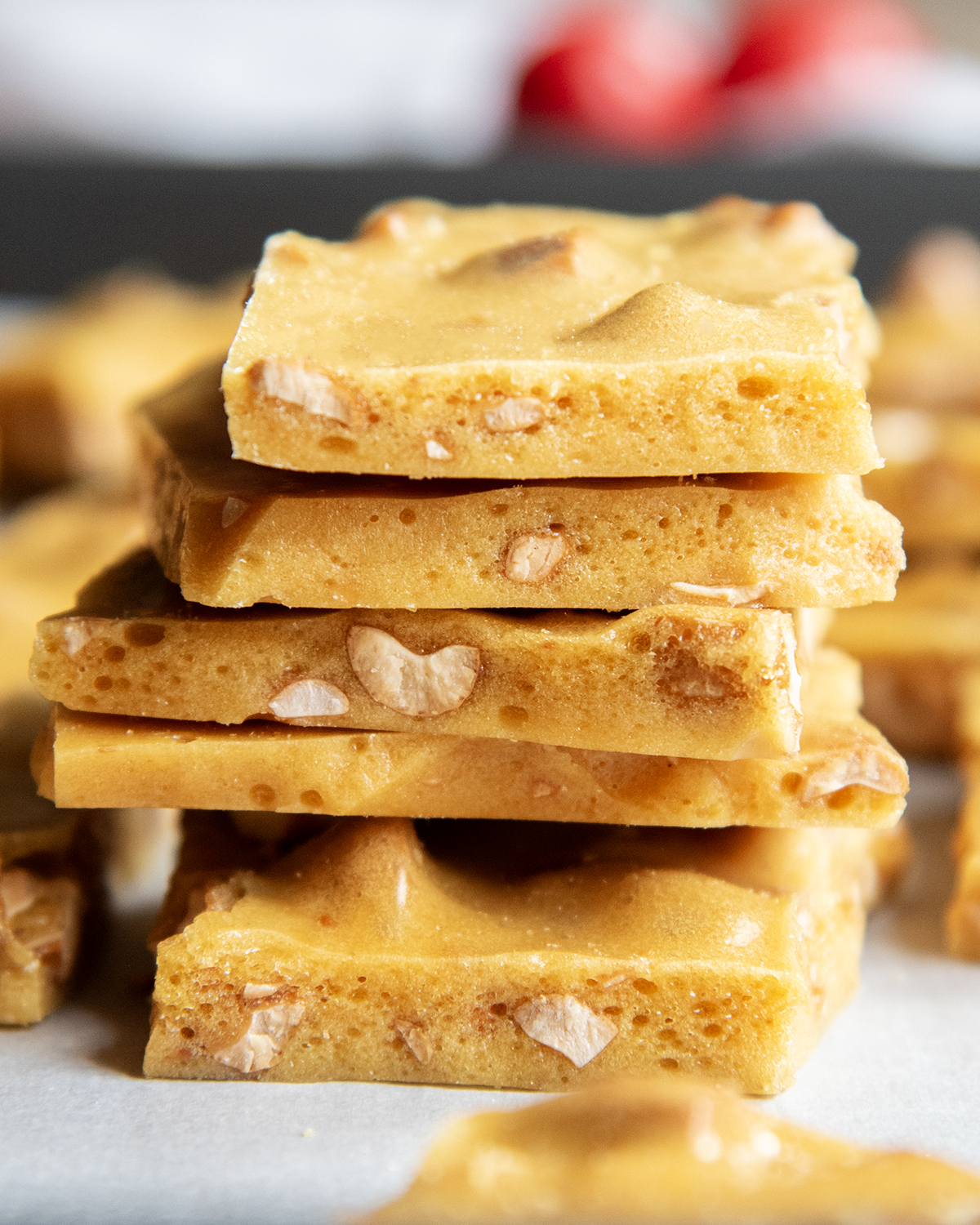 A stack of cashew brittle pieces on a cookie tray.