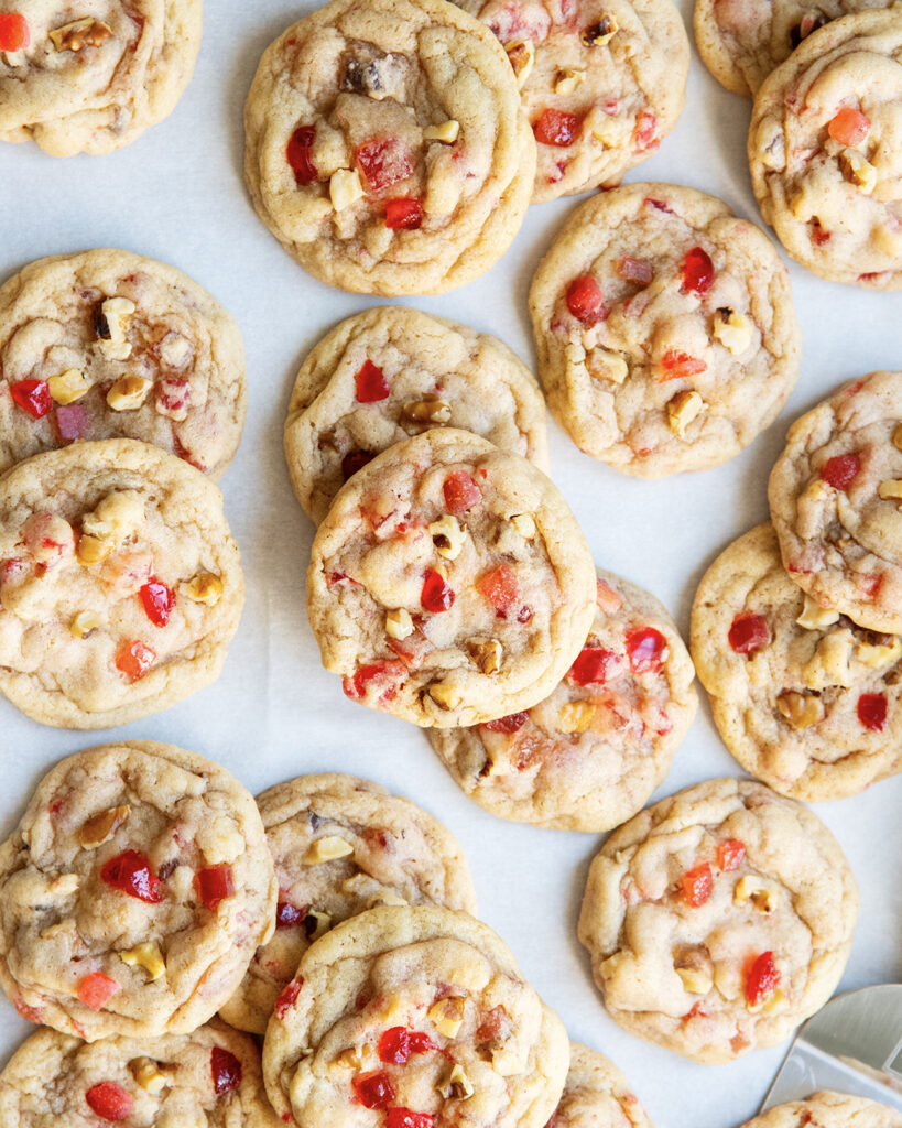 An above view of fruitcake cookies on a piece of parchment paper.