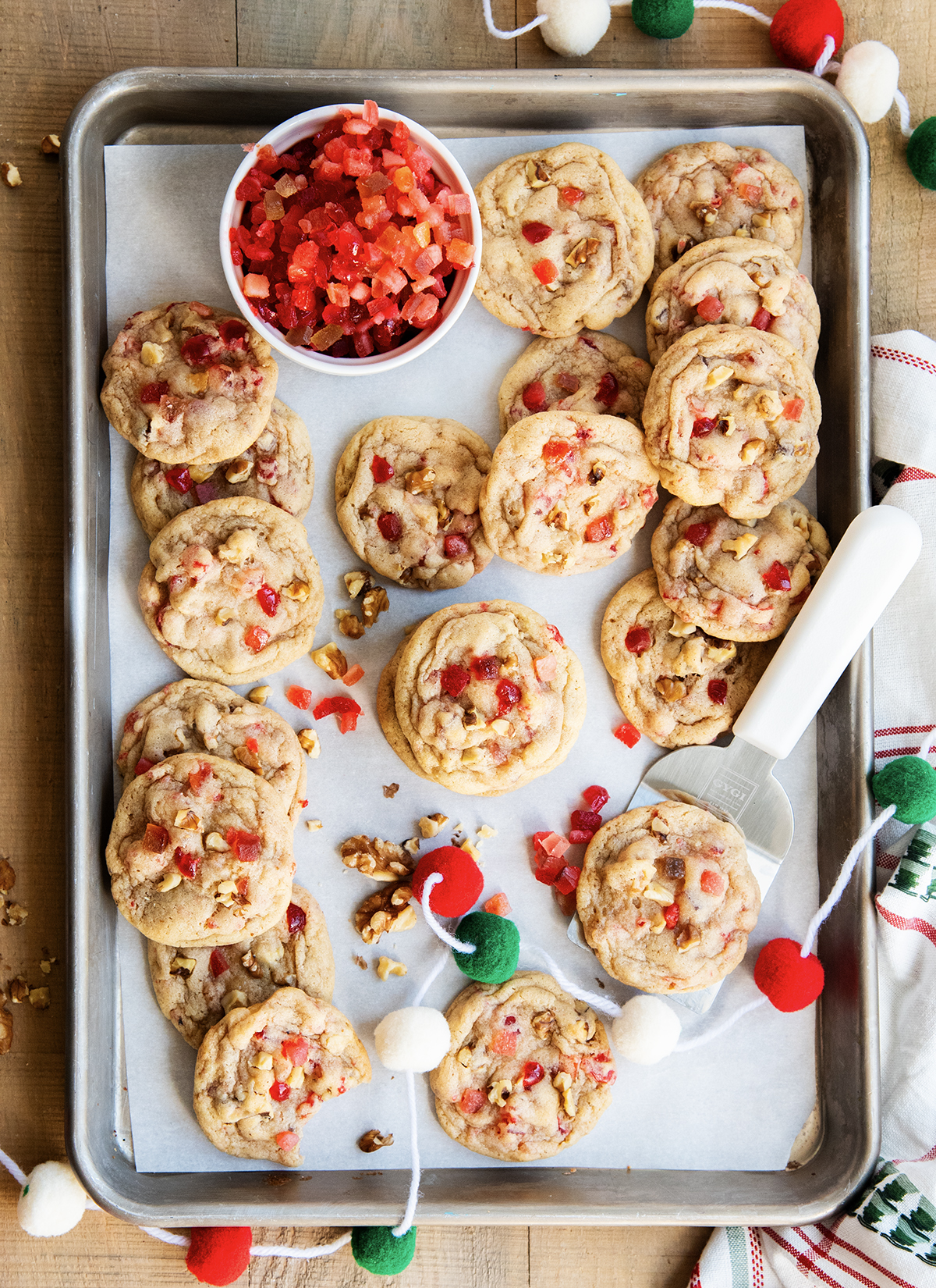 An above view of fruitcake cookies on a piece of parchment paper.