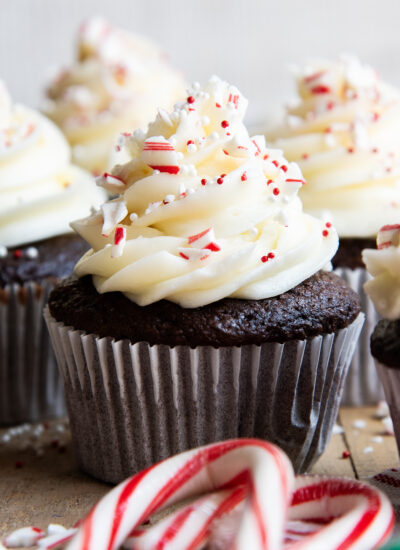 A peppermint frosted cupcake topped with candy cane pieces.