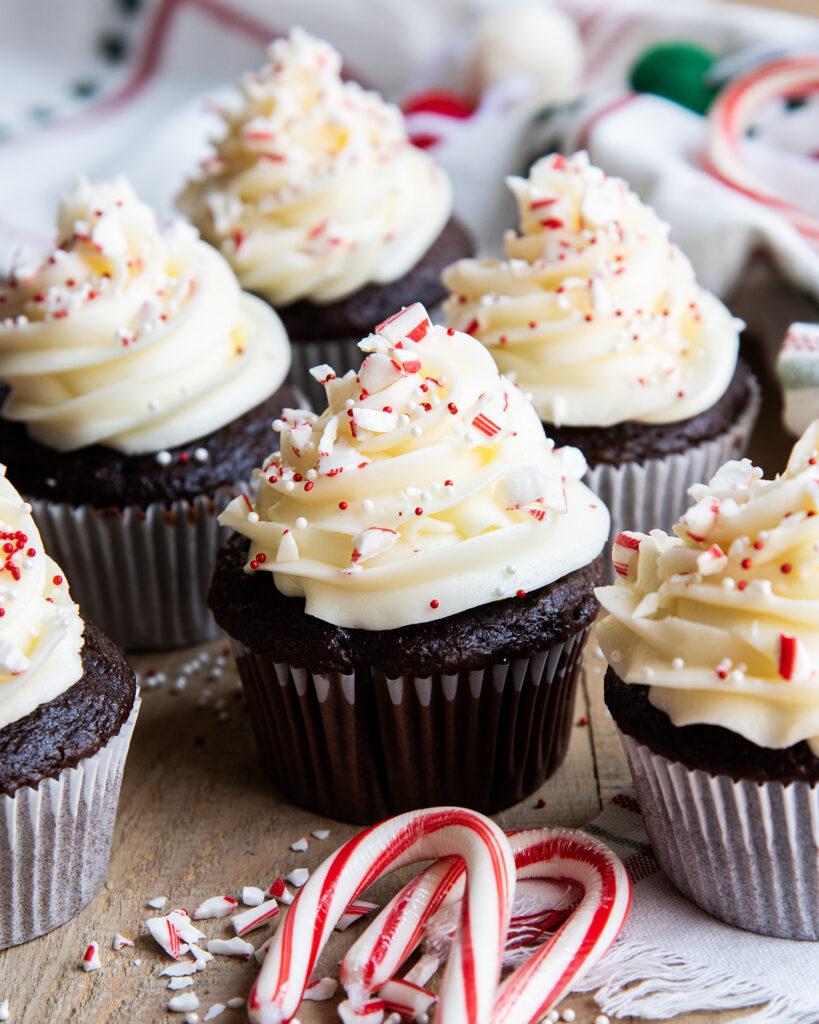 Chocolate cupcakes topped with a white colored peppermint frosting and red and white sprinkles.