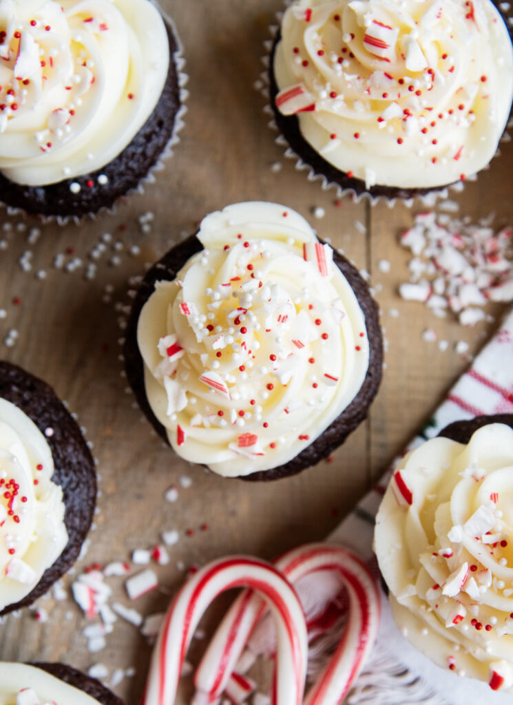 An above view of cupcakes topped with peppermint frosting with peppermint candy pieces.