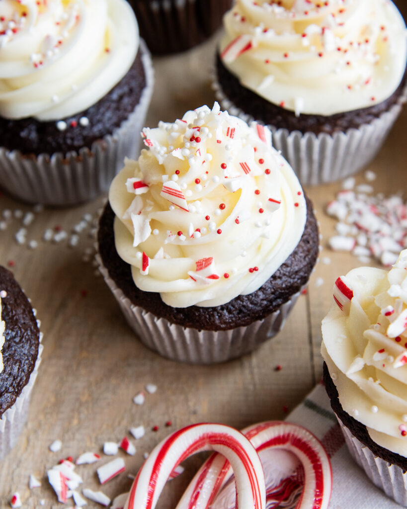 A peppermint frosted cupcake topped with candy cane pieces.