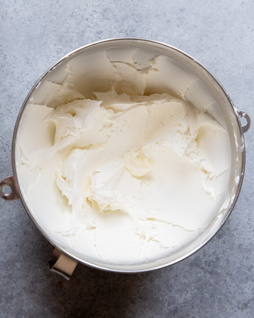 A stand mixing bowl full of fluffy white frosting.