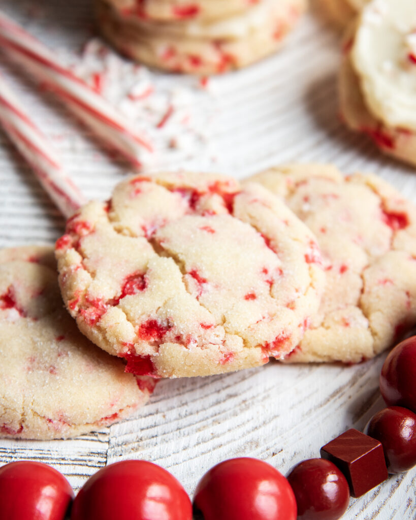 Candy cane filled sugar cookies on a white table.