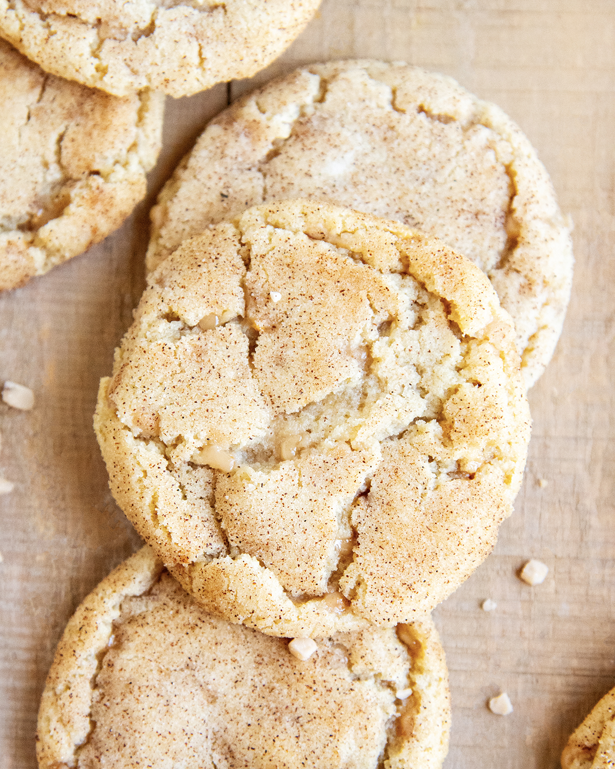 An above photo of crinkle topped toffee doodle cookies on a wooden table.