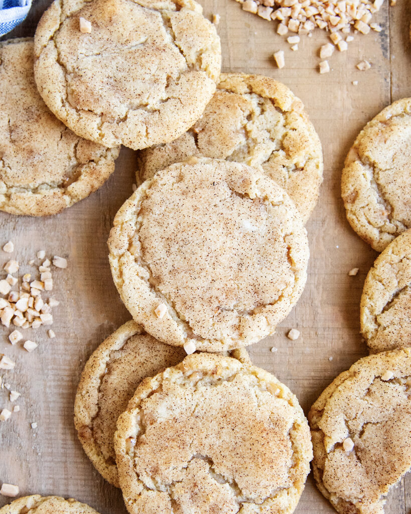 An above photo of crinkle topped toffee doodle cookies on a wooden table.