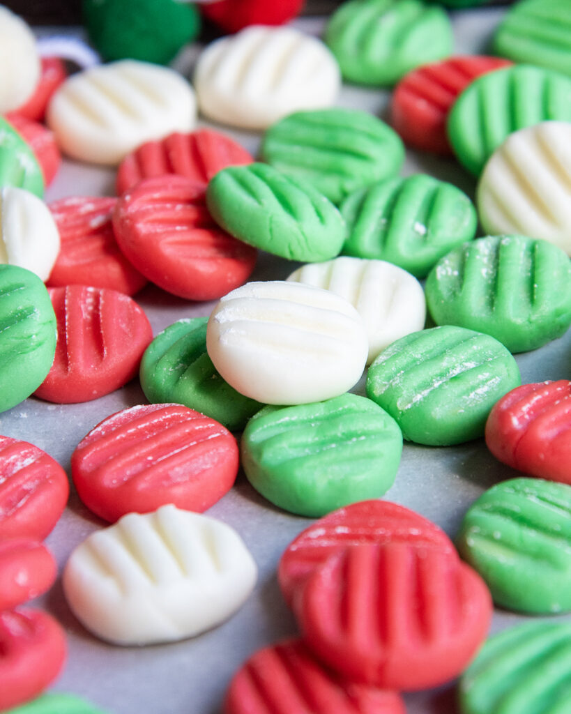 Red, white, and green cream cheese mints with fork tine impressions on the top. 