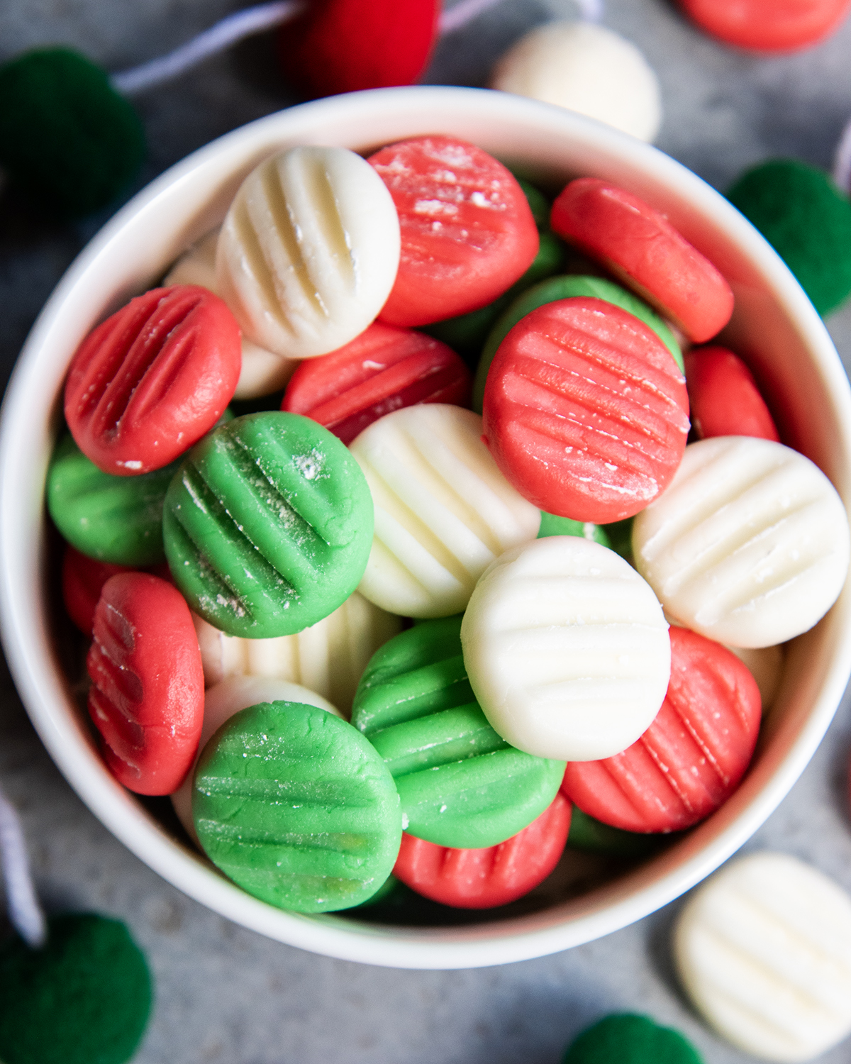 A bowl of red, white, and green cream cheese mints.