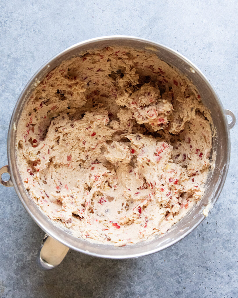 A bowl of fruitcake cookie dough in a metal bowl.