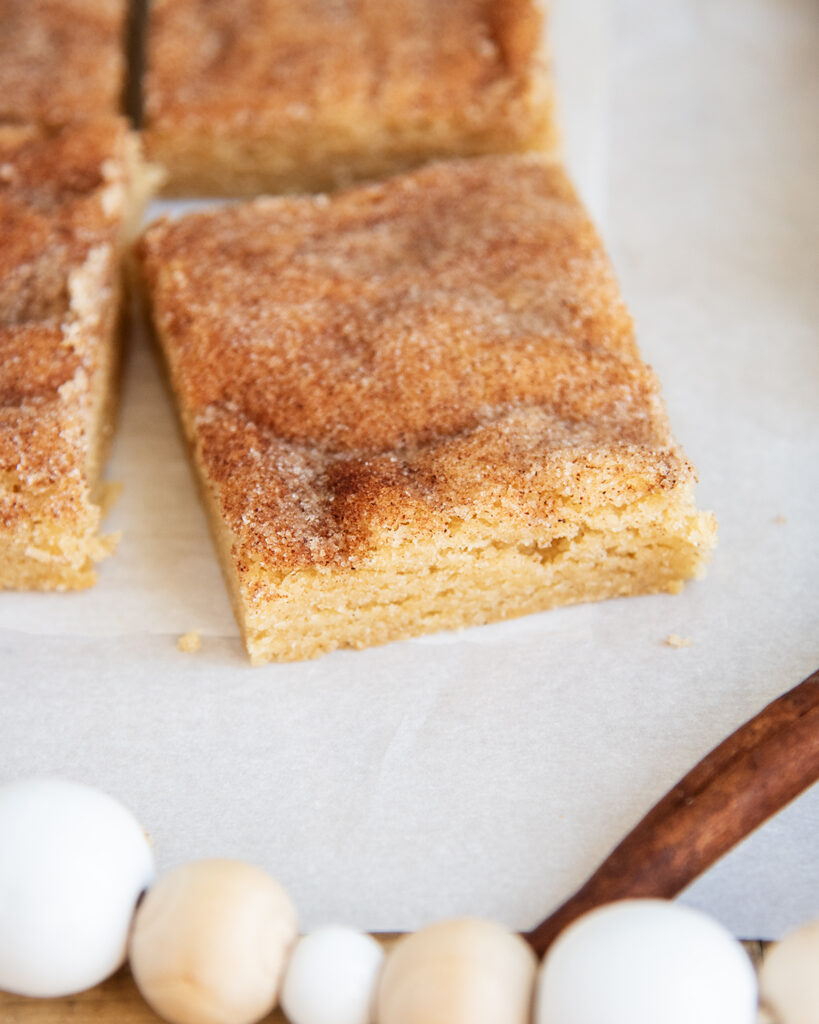 A snickerdoodle cookie bar on a piece of white parchment paper.