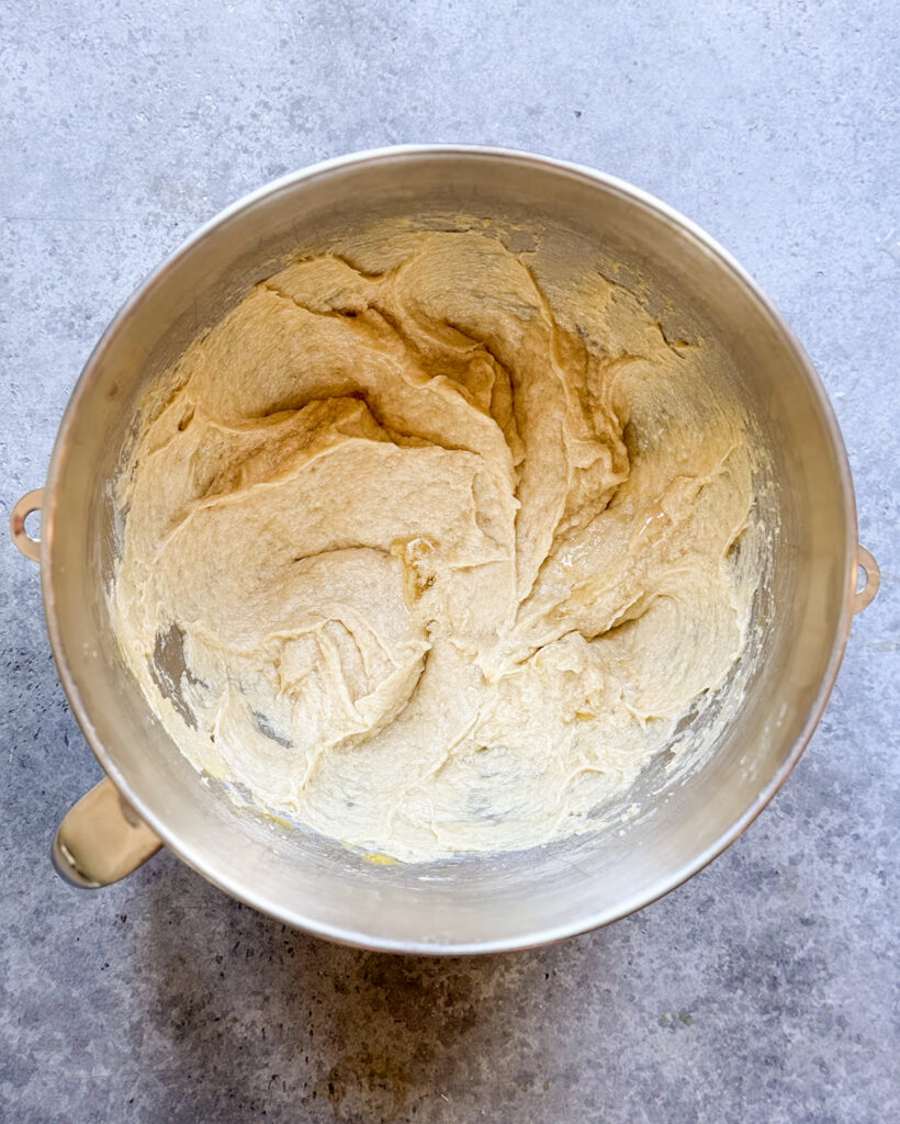 A bowl of mixed butter, sugar, and eggs.