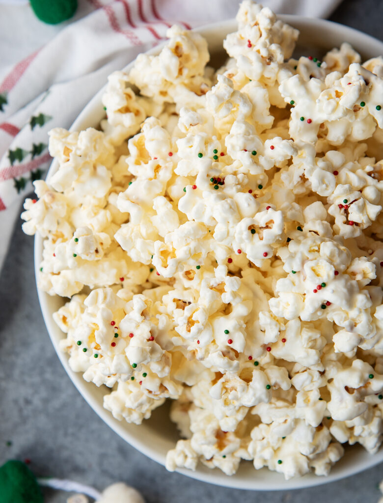 An above view of a bowl of white chocolate coated popcorn.