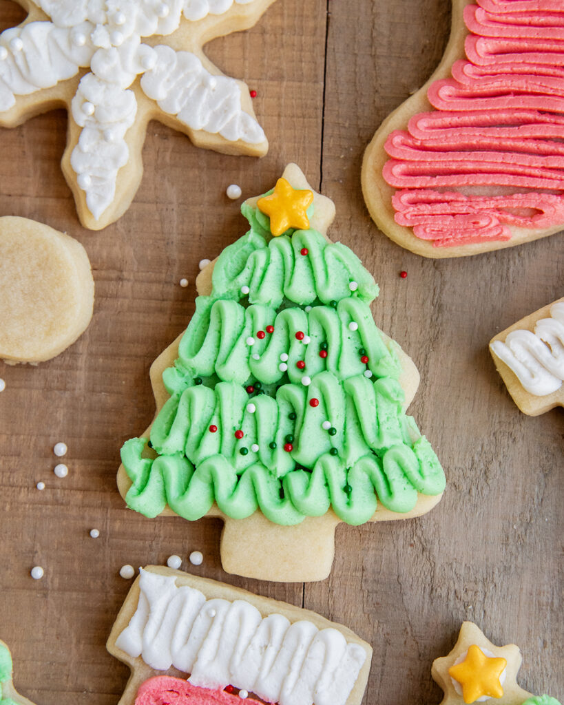 A tree shaped sugar cookie topped with green frosting, and a star on top. 