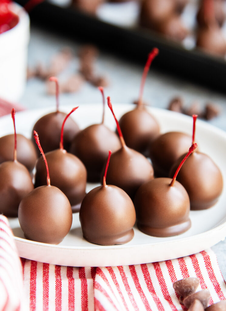 A plate of chocolate covered cherries.