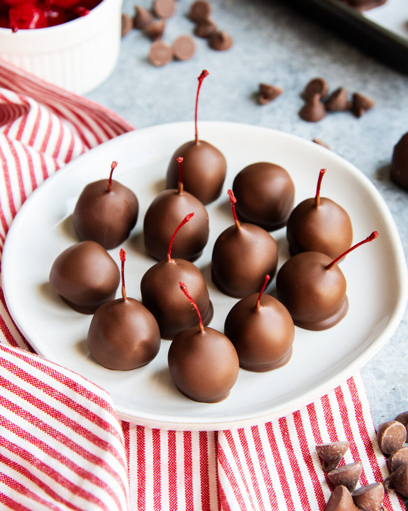 A plate of chocolate covered cherries.