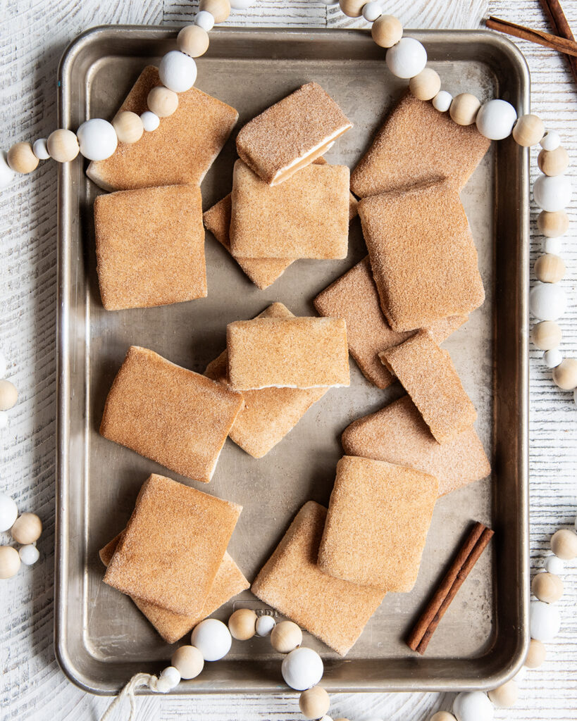 A top view of pieces of toffee coated in white chocolate, and cinnamon sugar.