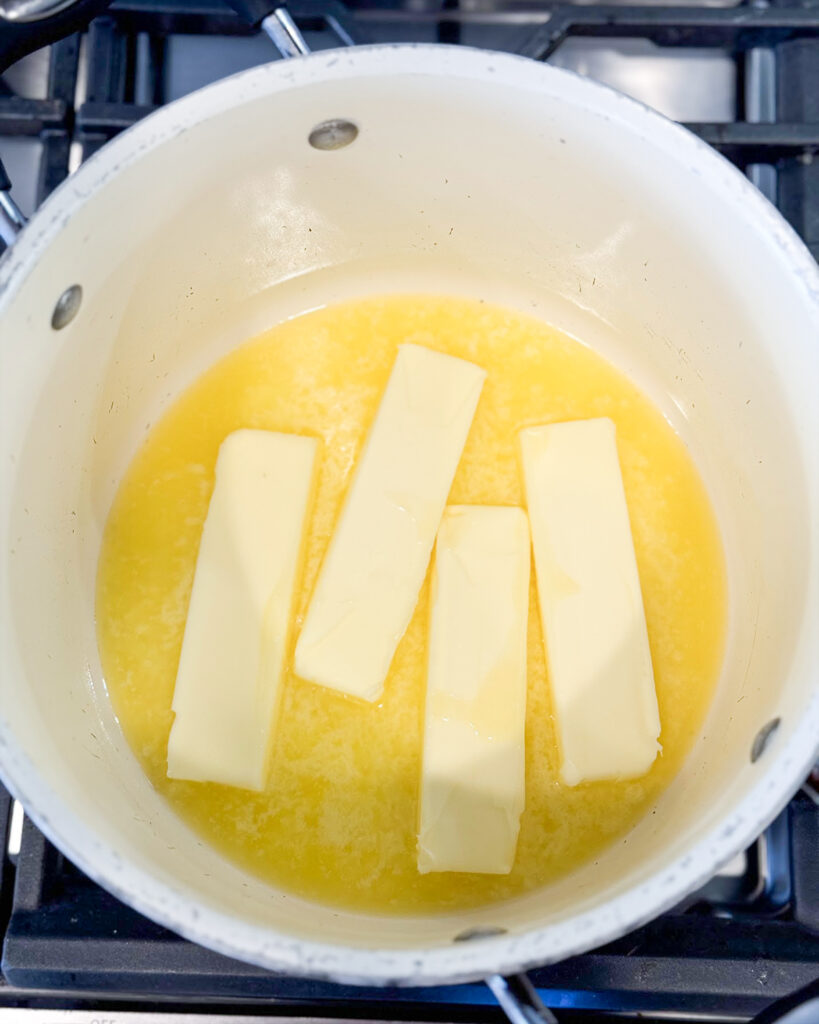 Four sticks of butter partially melted in a large pot. 