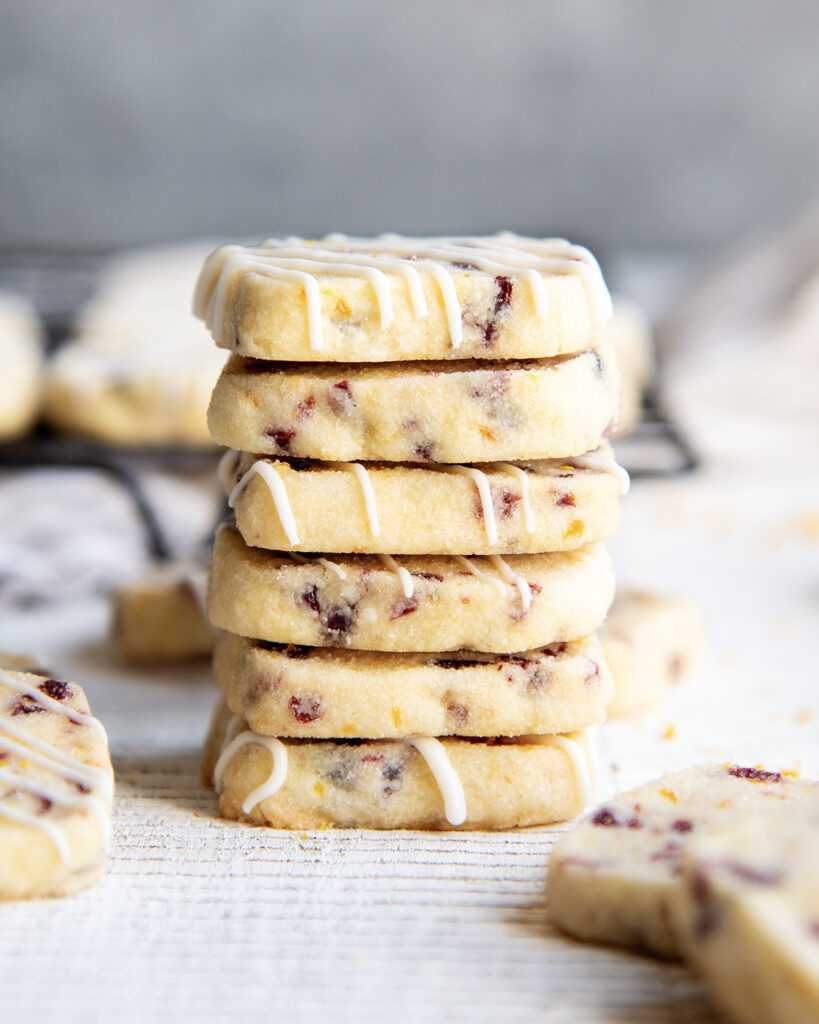 A stack of small cranberry orange shortbread cookies.